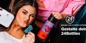 Young woman taking a playful selfie with a customized 24Bottles water bottle featuring a colorful design.