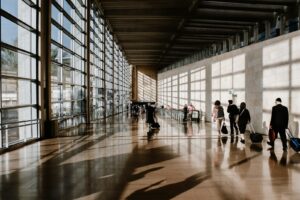 Reise Gutscheine: Reisende mit Koffer am Flughafen, günstiger buchen mit DealGutschein