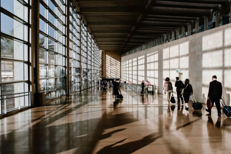 Reise Gutscheine: Reisende mit Koffer am Flughafen, günstiger buchen mit DealGutschein